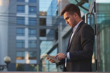 Fototapeta premium Businessman holding a tablet and pointing finger of the other hand on tablet
