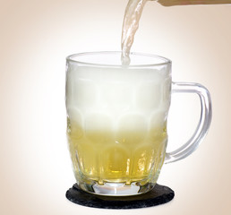 Mug of light shandy beer on slate mat isolated 