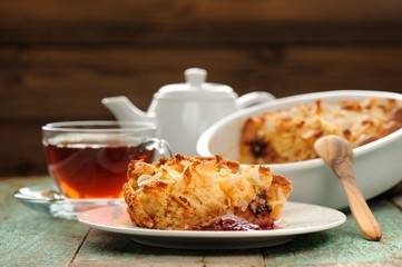 Panettone pudding and steaming hot black tea on shabby wooden