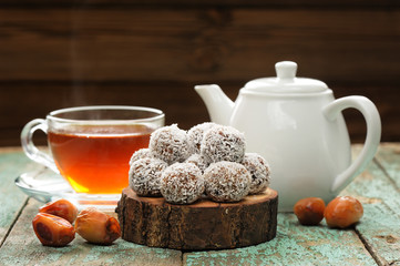 Homemade vegan sweets in coconut shavings served with steaming