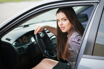 Fototapeta na wymiar Young, attractive woman driving a car, going home from work