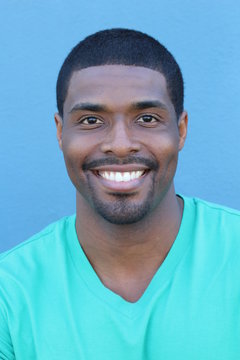 Close Up Portrait Of A Laughing African American Man Posing Against Blue Background