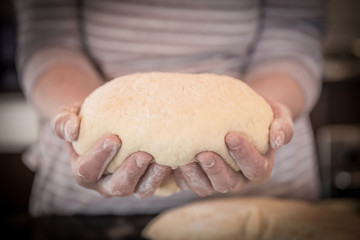 Female hands holding dough
