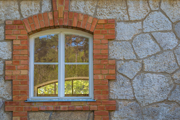 Fototapeta na wymiar Window on stone wall
