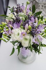 Modern bride bouquet white, violet, green flowers. Rustic wedding style of beautiful buttercup ranunculus, fresia, lavender, peony. Marriage