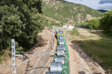 Freight train on an Iberian gauge railway track between Leon and Gijon on its way through La Pola de Gordon, Leon Province, Spain