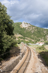 Iberian gauge railway track between Leon and Gijon on its way through La Pola de Gordon, Leon Province, Spain. In the background can be seen the town of Puente de Alba