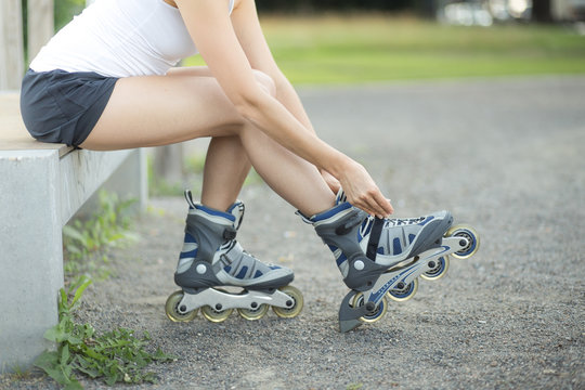 Junge Frau zieht sich Inlineskater an