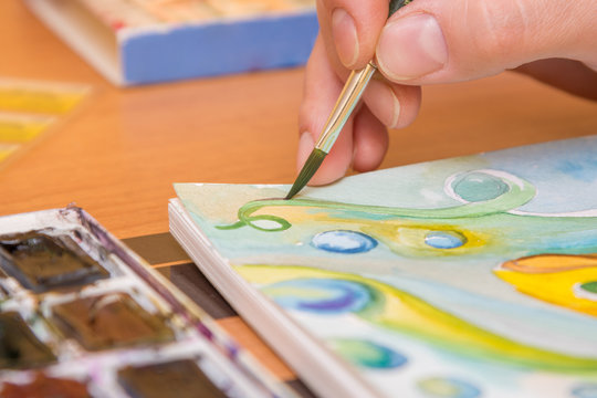 Close-up of the process of drawing watercolor on paper