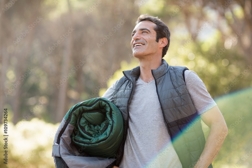Poster man smiling and holding a sleeping bag