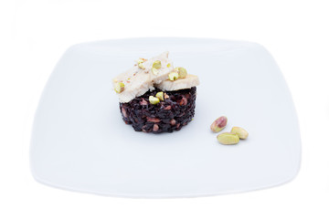 Black rice with fish and pistachios on a white background