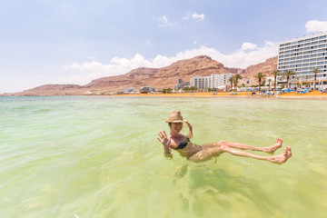 Young woman tourist swimming floating salty water, Dead sea.