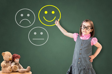 Cute little girl wearing business dress and select happy on satisfaction evaluation on green chalk board. 