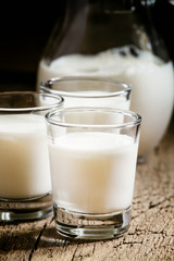 Goat milk in glasses, vintage wooden background, selective focus