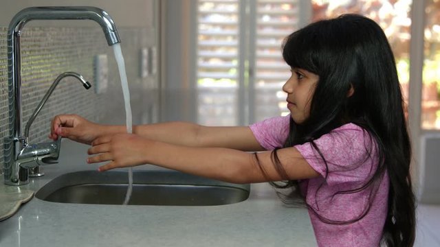 Cute girl washing her hands