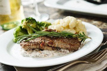 Beef with rosemary, mushroom sauce, broccoli and cauliflower