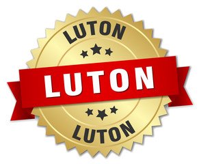 Luton round golden badge with red ribbon
