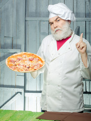Bearded cook with pizza