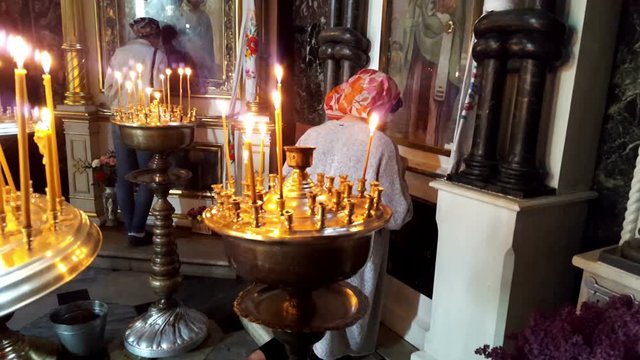 Praying women in front of icons in the Orthodox Church