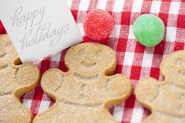 close-up shot of happy holidays tag with gingerbread candies.