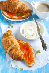 Croissant with salmon and cup of coffee.