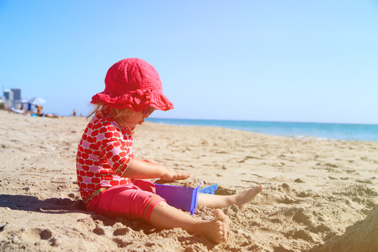 little girl play with toys on beach