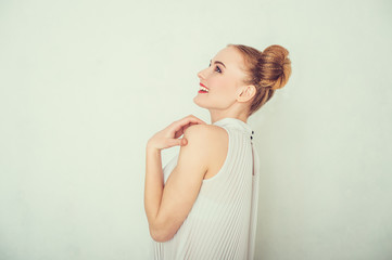 Close-up portrait of surprised beautiful girl with funny hairstyle looking up