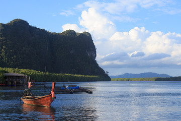 Fototapeta na wymiar wooden long-tail boat on blue sea water and sunlight reflect, nature landscape at Trang Thailand