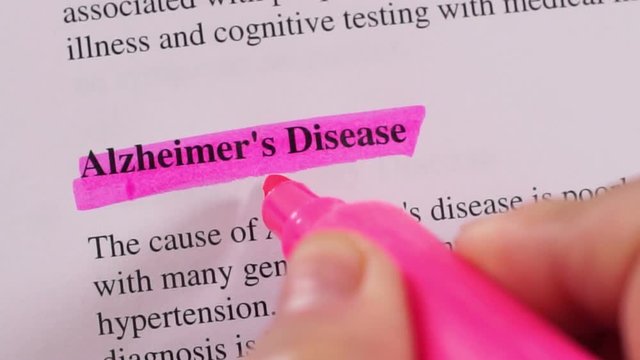 Close up shot of a person that could be a doctor or a nurse highlighting the medical term or condition Alzheimer's Disease.