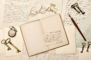 Open book, old letters, antique accessories. Vintage background