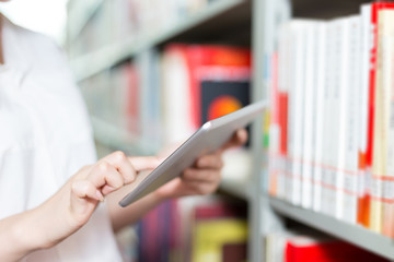 young beautiful asian girl university student with tablet in lib