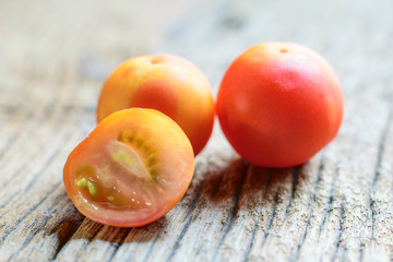  ripe tomatoes on wood background