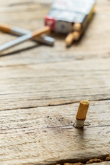 Tobacco in the cigarette, lying on a wooden table.