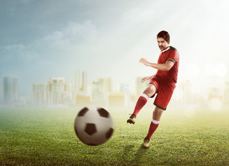 Obraz na płótnie Canvas Asian football player kick ball