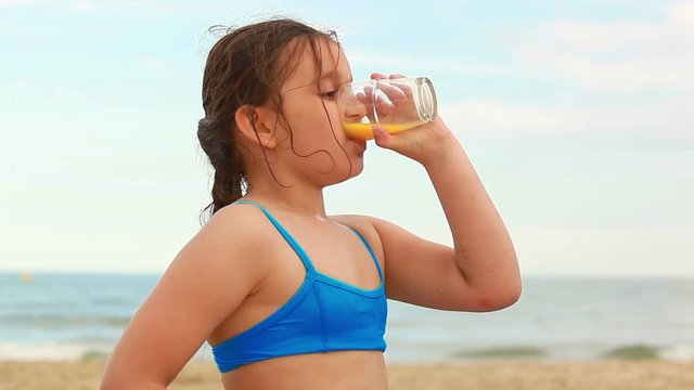 Girl drinking juice on the beach