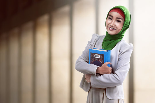 Pretty asian muslim woman holding koran