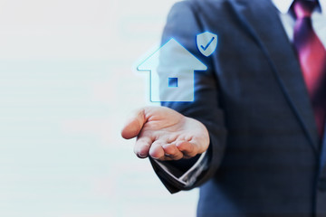 Businessman presenting virtual house with protection on his palm