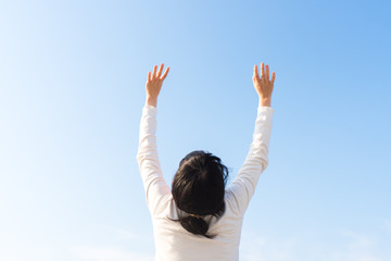手を空にかざす女性