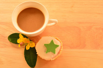 flowers and cupcake and coffee on the wooden floor .