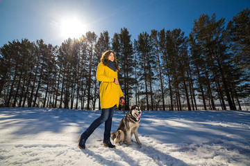 woman walking with dog in the winter forest