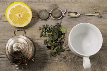 Herb's tisane with vintage silverware on rustic wooden table
