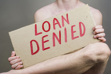 man holding a sign loan is denied