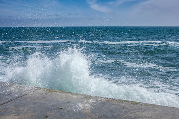 Fototapeta premium big waves on rocky coast and blue sea