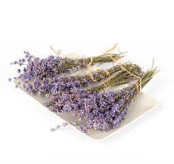 Plate with dry lavender flowers isolated on white