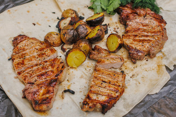 Grilled steak, bacon and potatoes with herbs lies in the pita. The concept of eating outdoors in the weekend.
