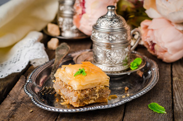 Walnuts baklava in oriental tray on wooden background. East sweets. Ramadan food. Selective focus