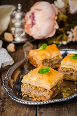 Walnuts baklava in oriental tray on wooden background. East sweets. Ramadan food. Selective focus
