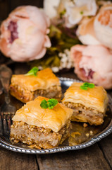 Walnuts baklava in oriental tray on wooden background. East sweets. Ramadan food. Selective focus