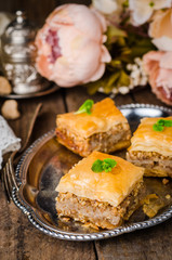 Walnuts baklava in oriental tray on wooden background. East sweets. Ramadan food. Selective focus