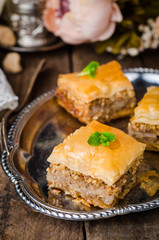 Walnuts baklava in oriental tray on wooden background. East sweets. Ramadan food. Selective focus